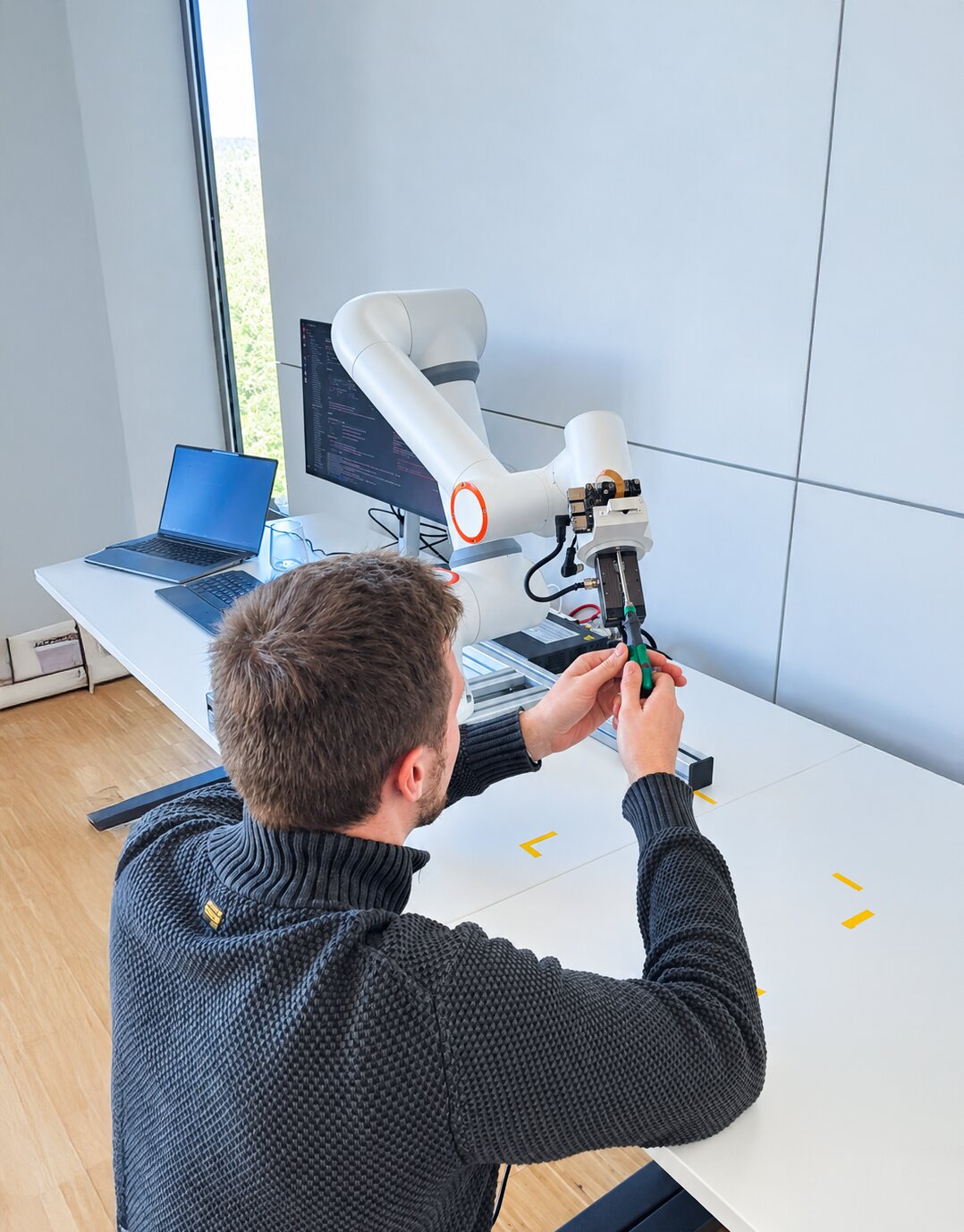 Employee mounting the gripper on a robot arm