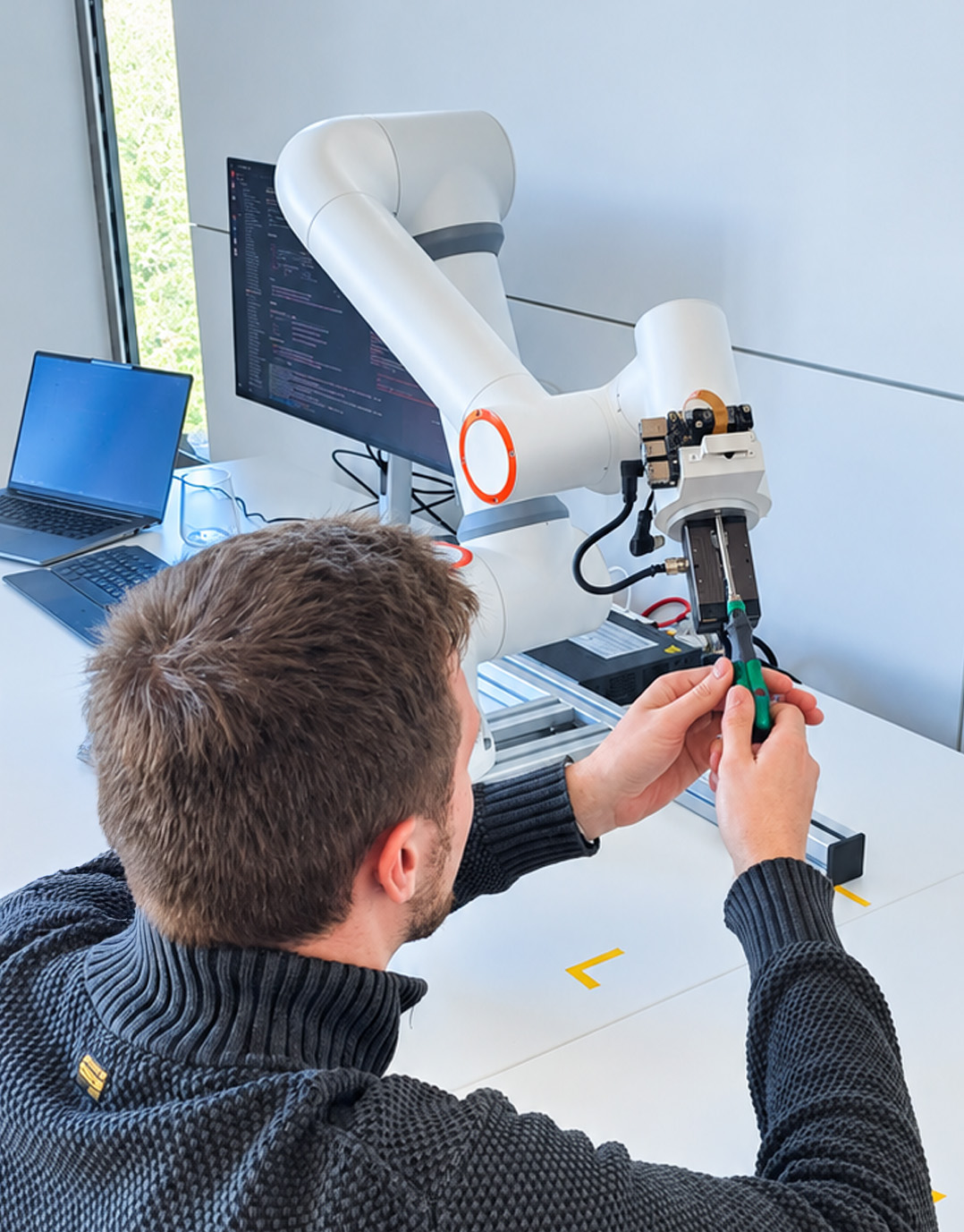 Employee mounting the gripper on a robot arm